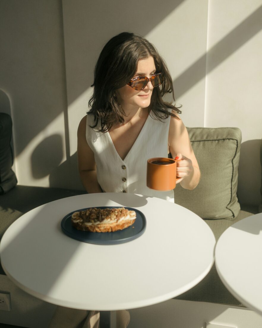 WOMAN ENJOYING HER COFFEE AT A CAFE