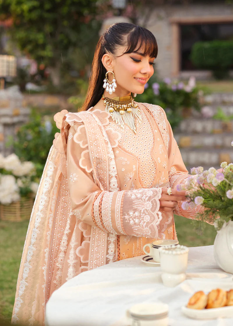 Woman in a peach embroidered outfit holding flowers outdoors