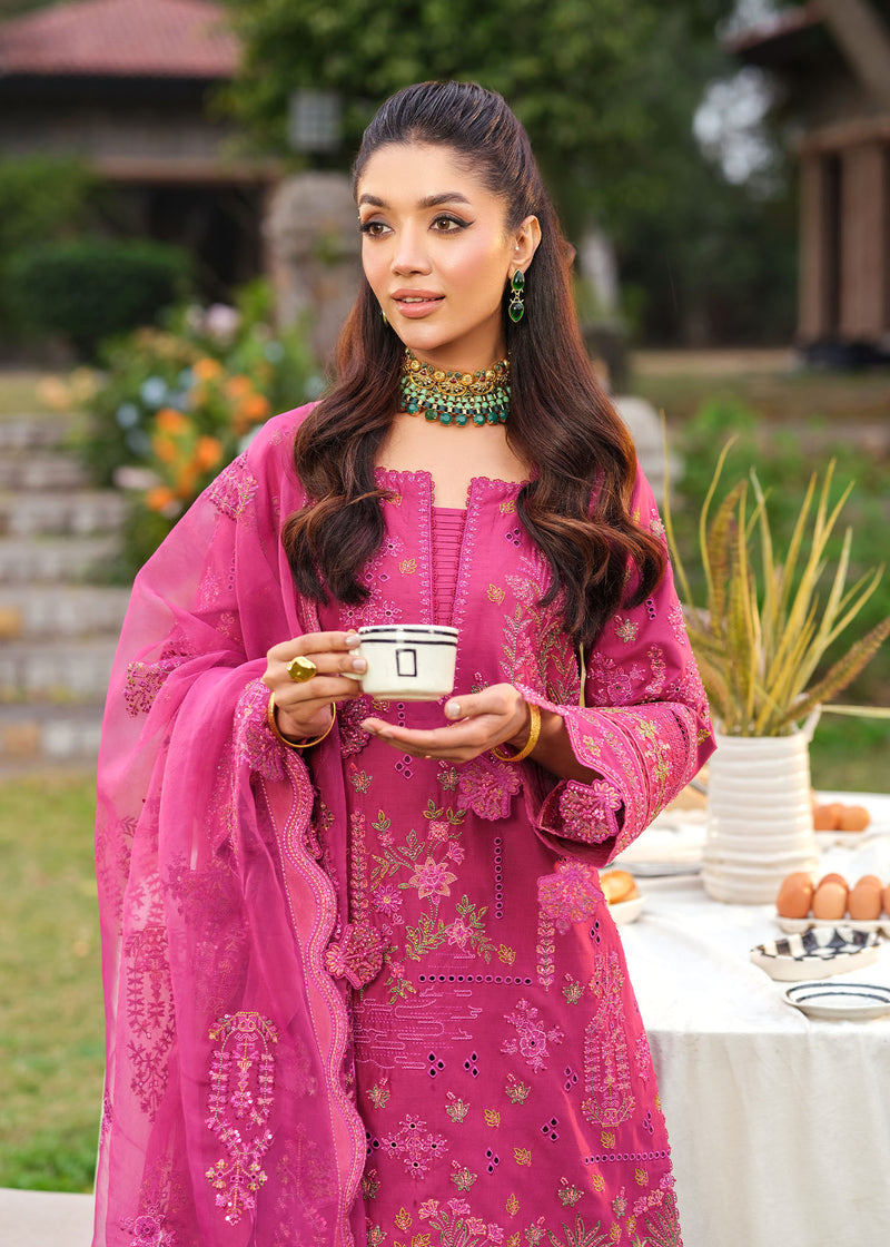 Woman in a pink traditional outfit holding a cup outdoors