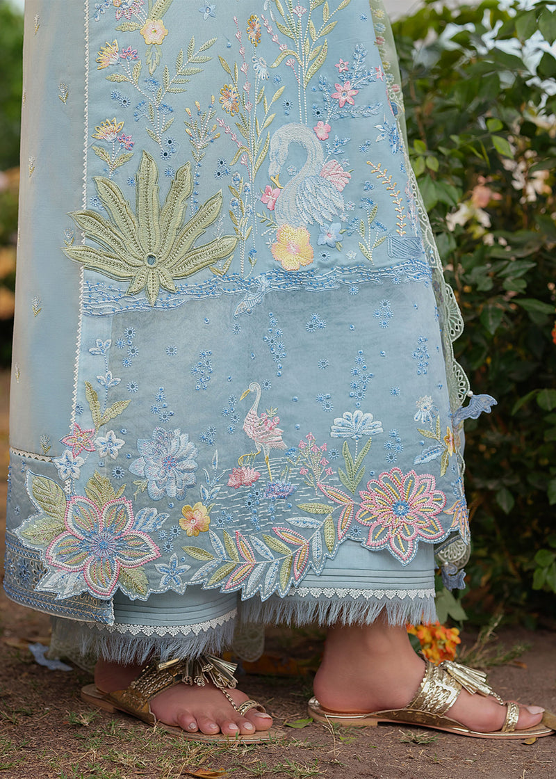Embroidered fabric with floral and swan designs, worn by a person outdoors.
