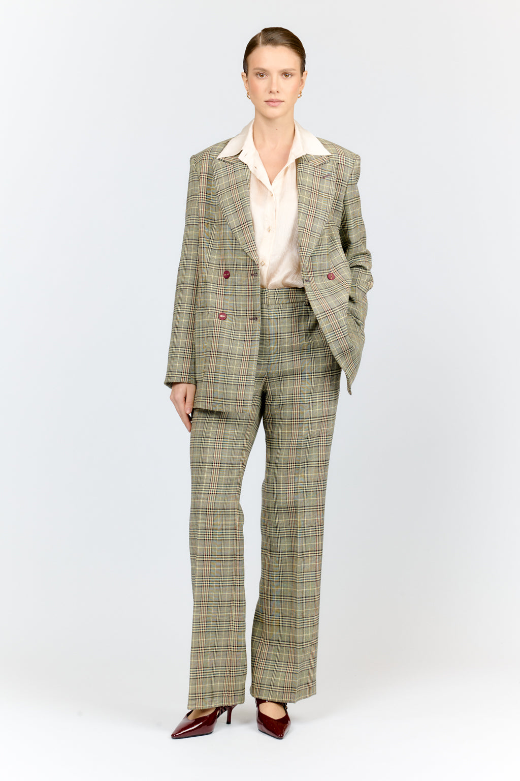 Woman wearing a plaid suit with a white shirt on a white background