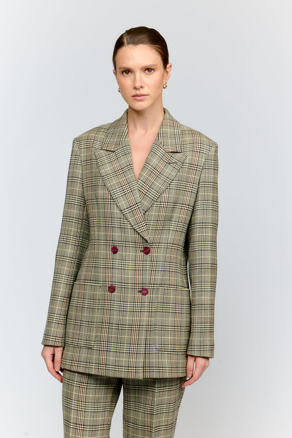 Woman wearing a plaid suit with a white background