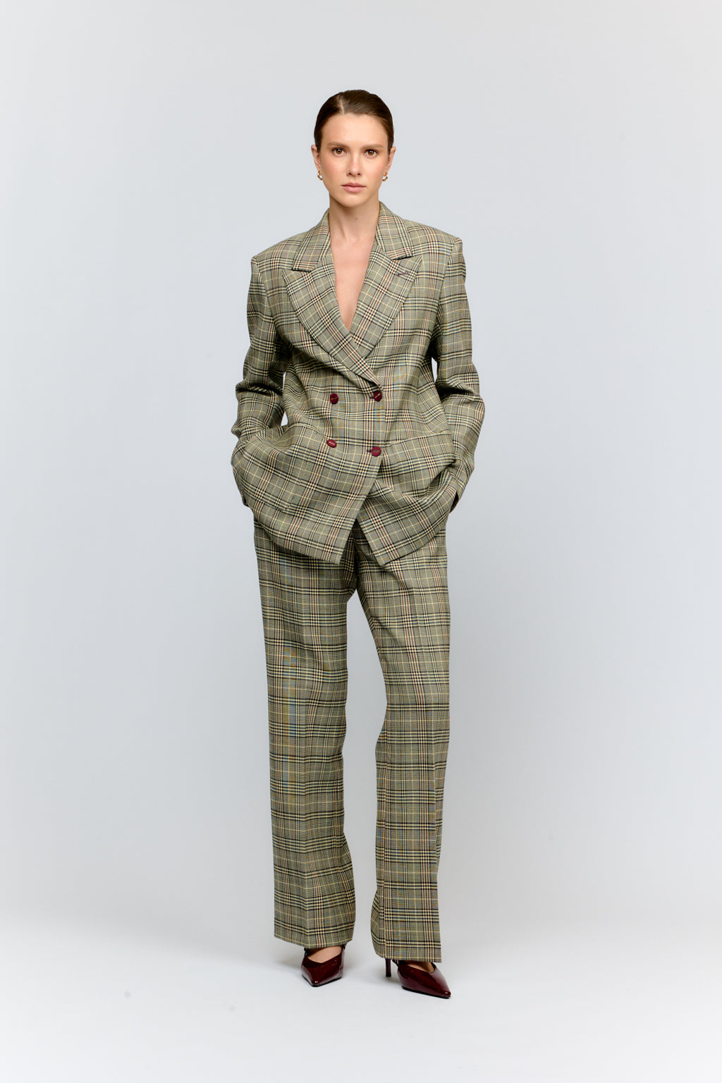 Woman wearing a plaid suit on a white background