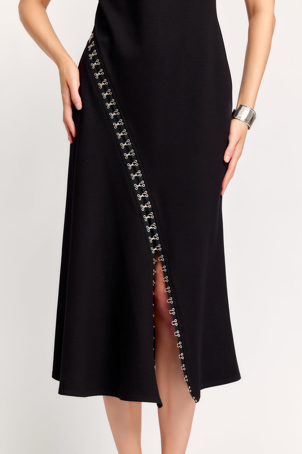 Black dress with decorative side panel on a white background