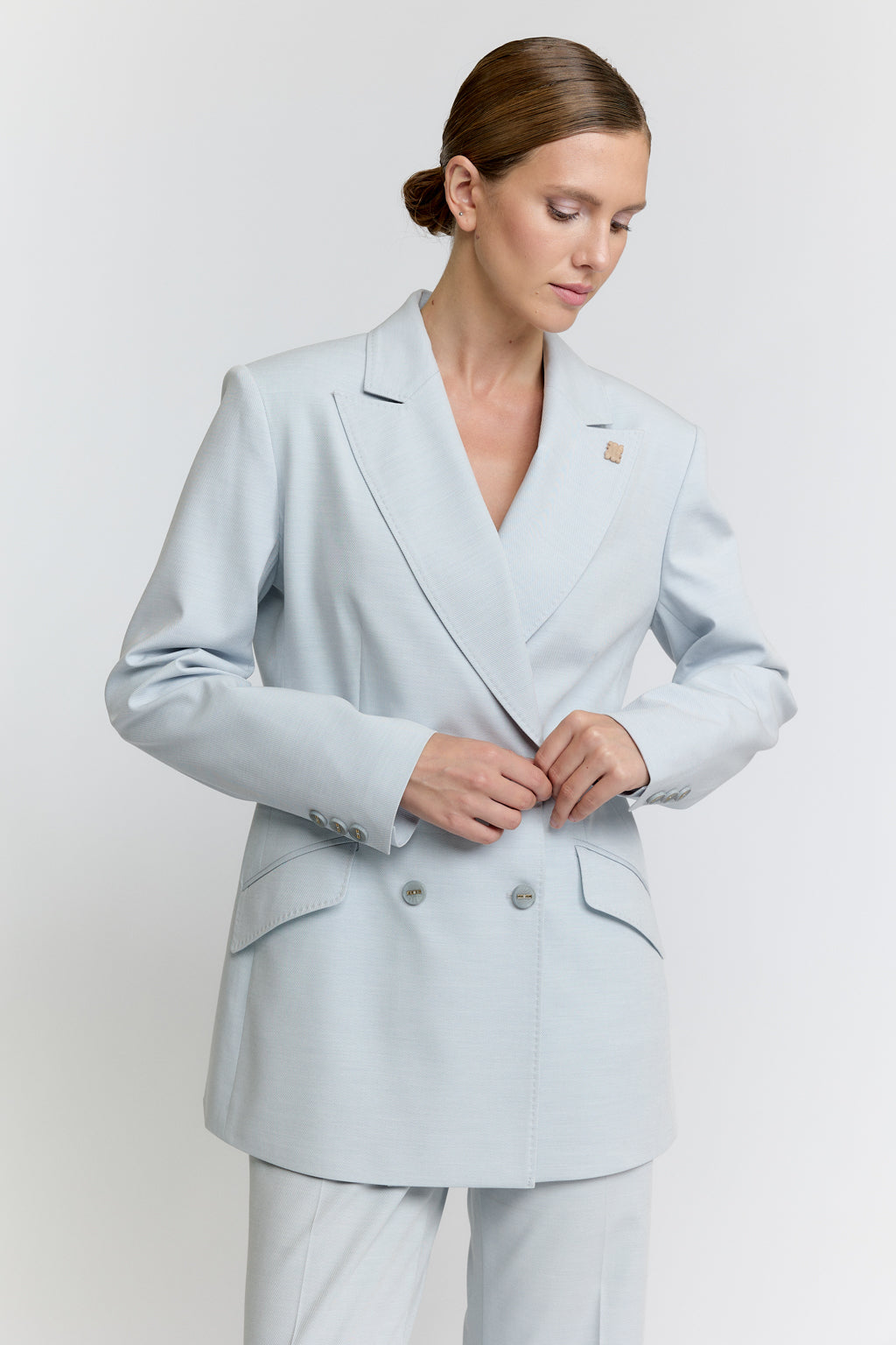 Woman wearing a light blue suit against a white background