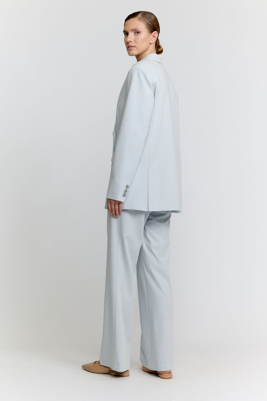 Woman wearing a light blue suit on a white background