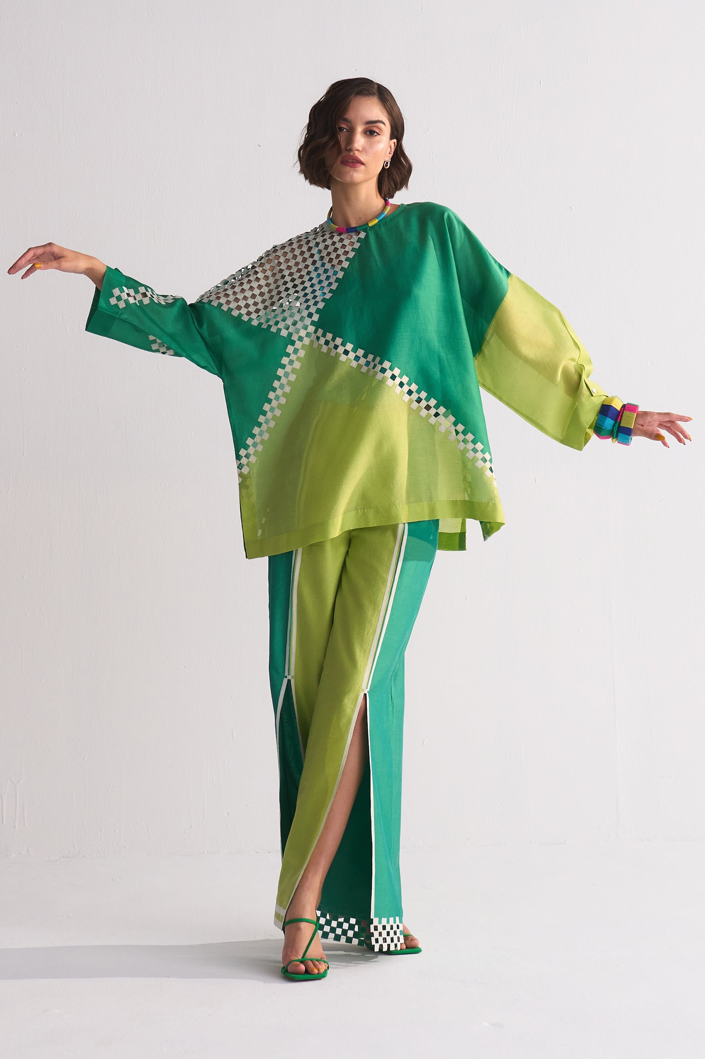 Woman wearing a green and yellow outfit with a white background