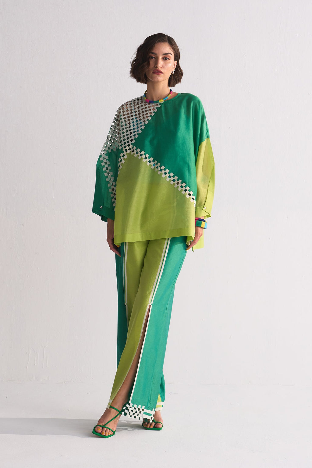 Woman wearing a green and yellow outfit with a white background