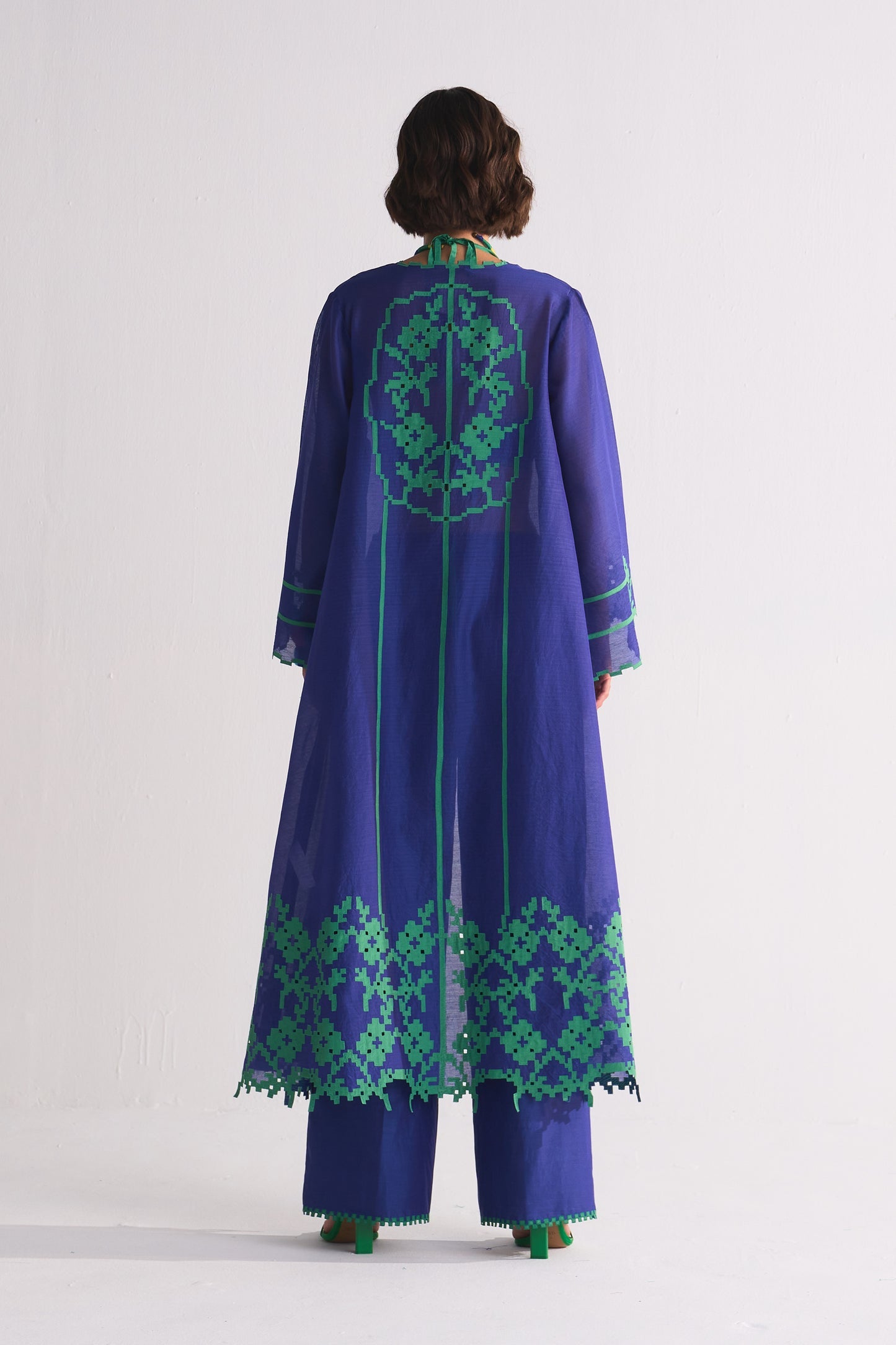 Purple embroidered dress with green patterns on a white background
