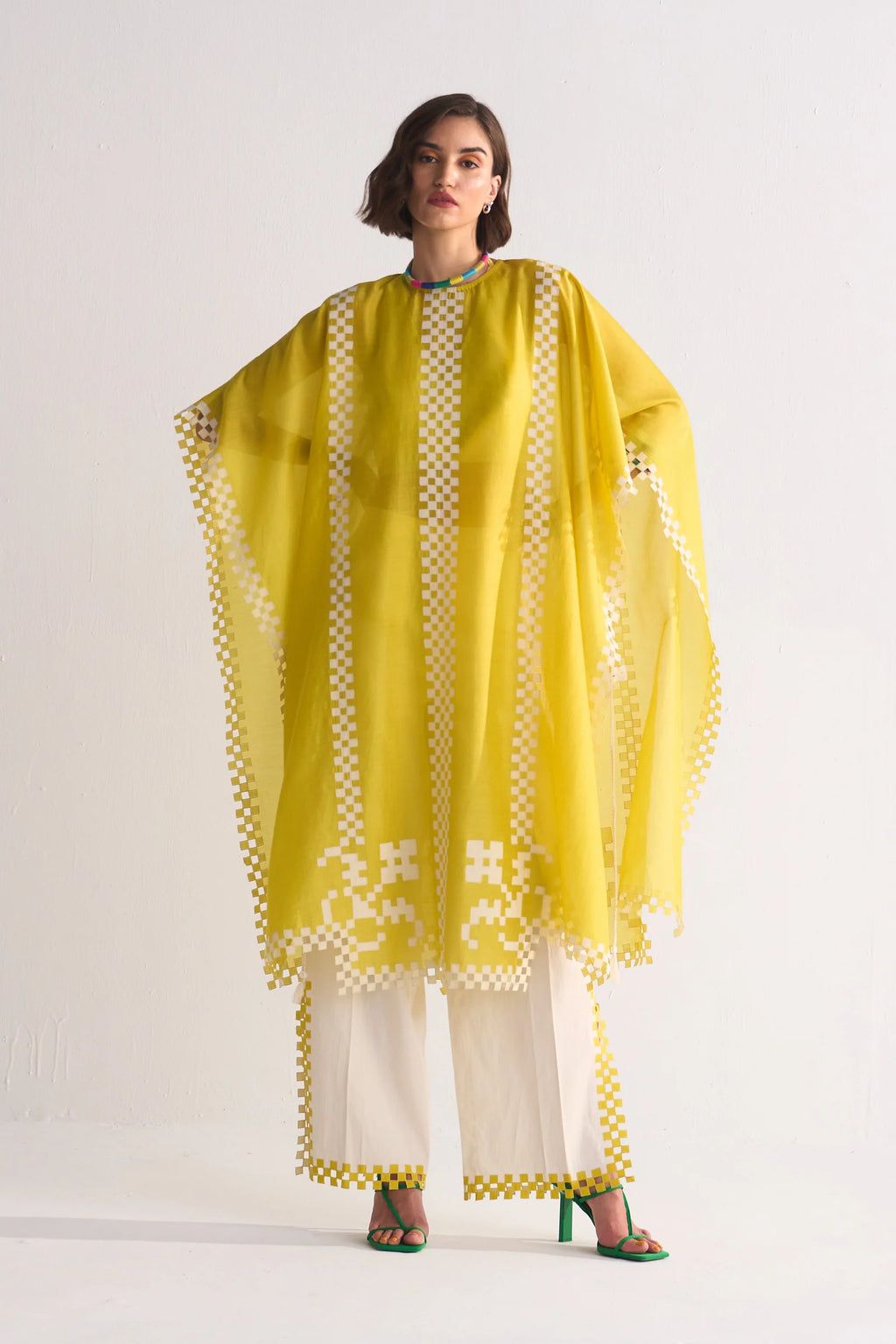 Woman wearing a yellow and white traditional outfit with a white background