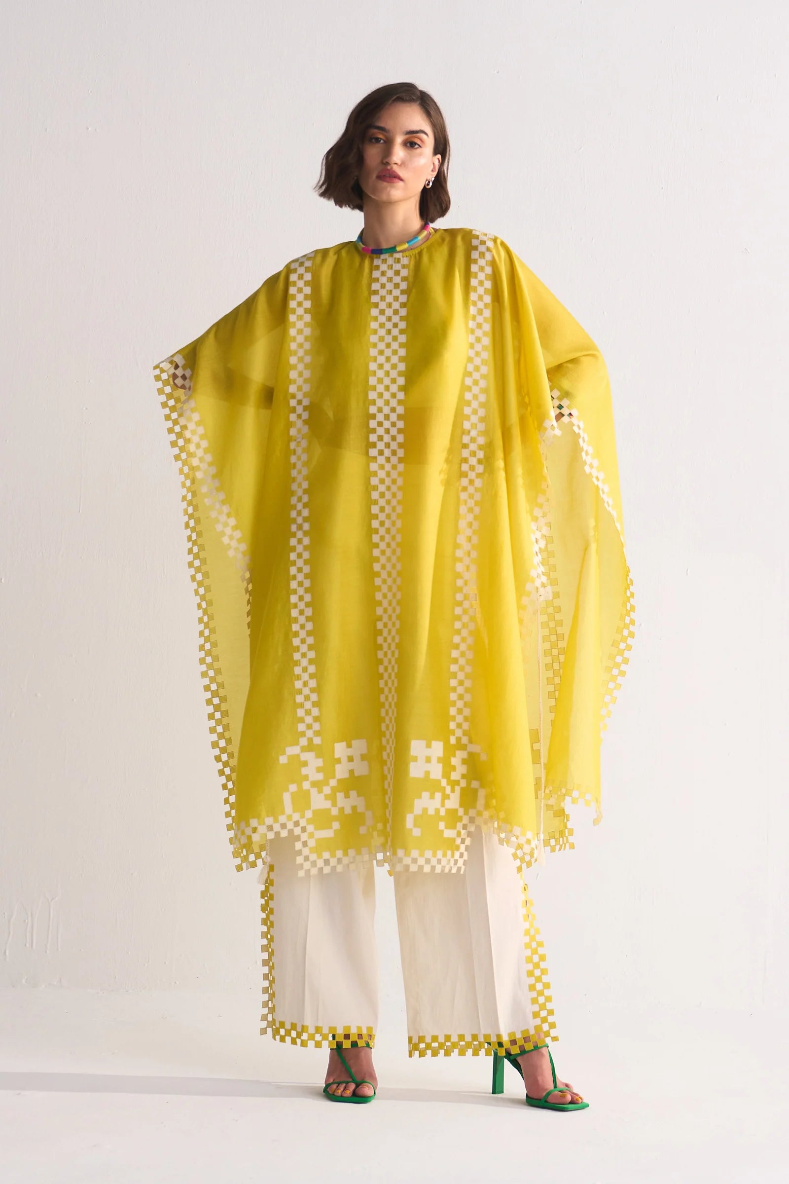 Woman wearing a yellow and white traditional outfit with a white background