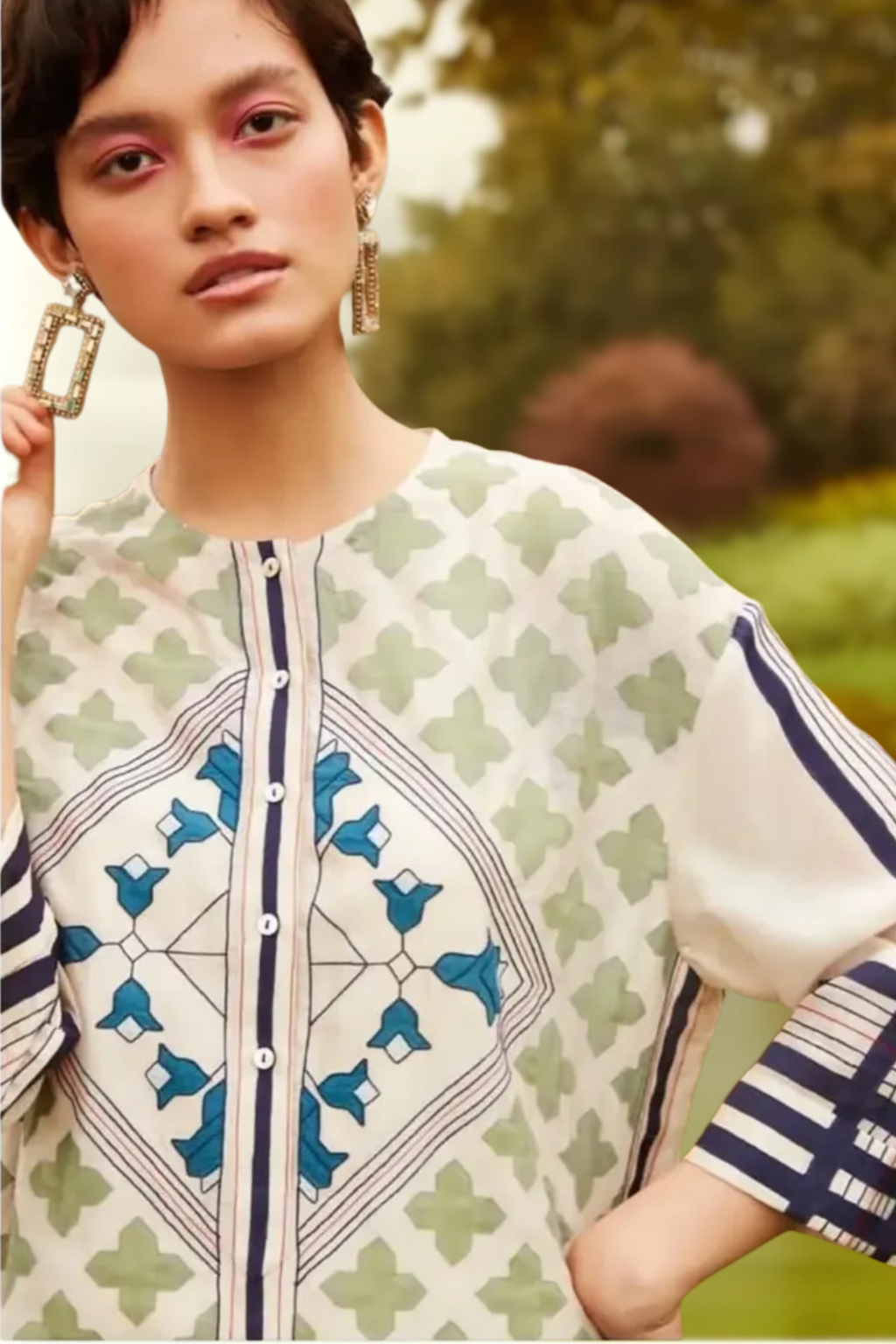 Woman wearing a patterned outfit with a blurred natural background