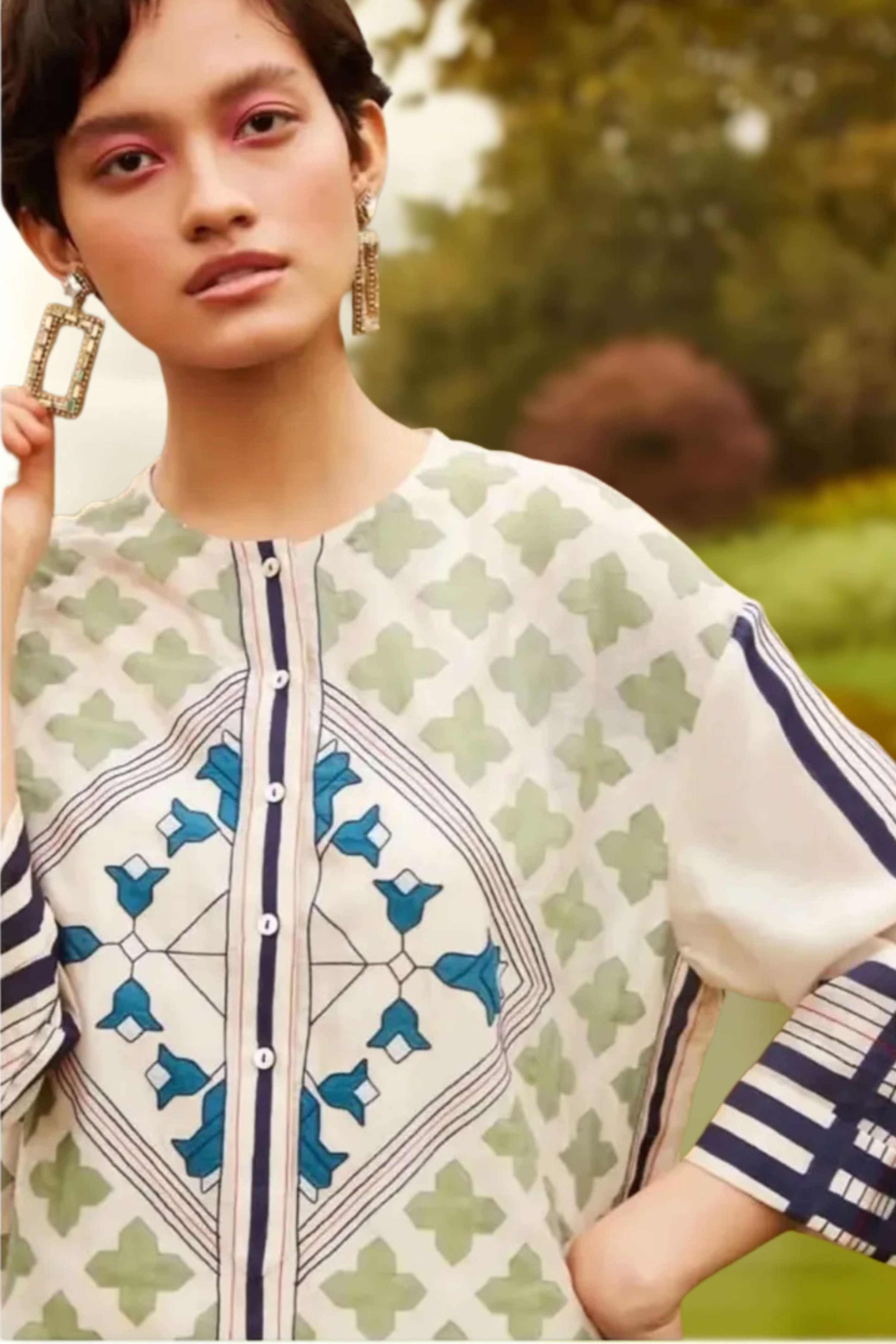 Woman wearing a patterned outfit with a blurred natural background