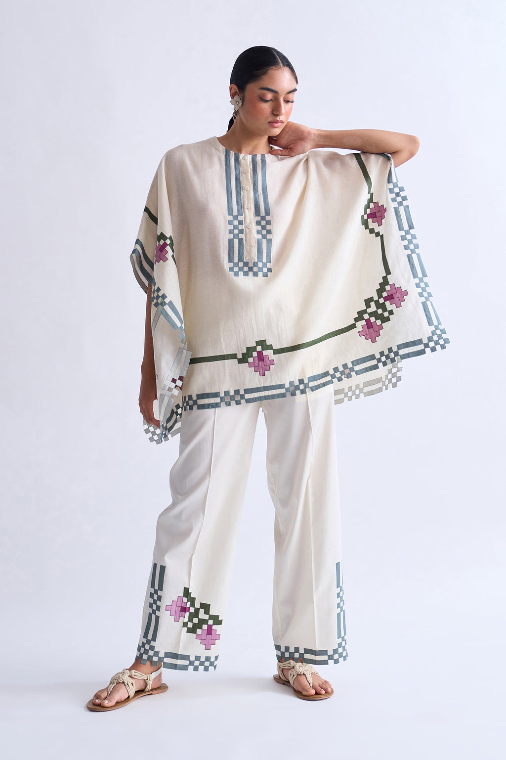 Woman wearing a traditional outfit with embroidery on a plain background