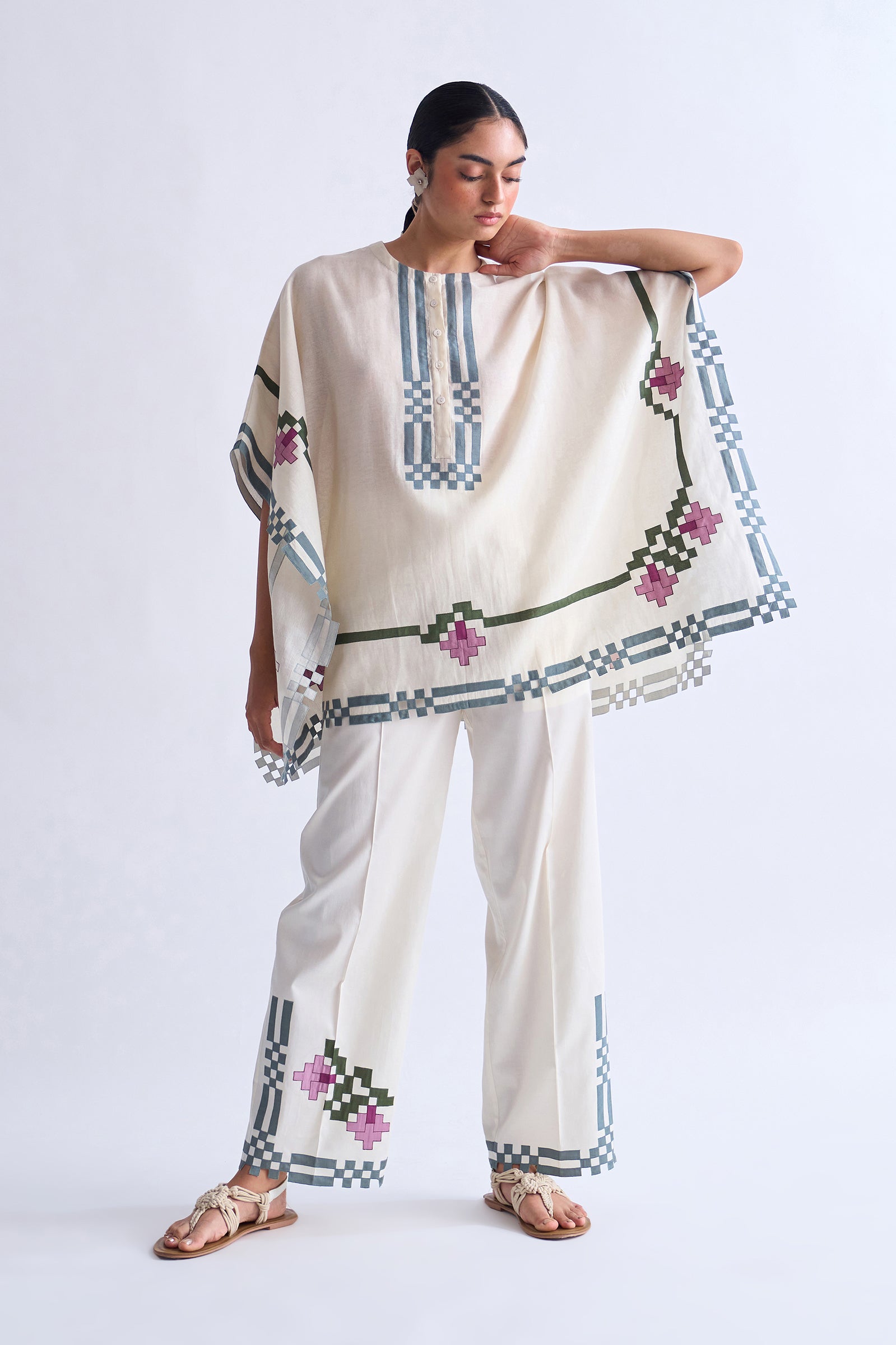 Woman wearing a traditional outfit with embroidery on a plain background