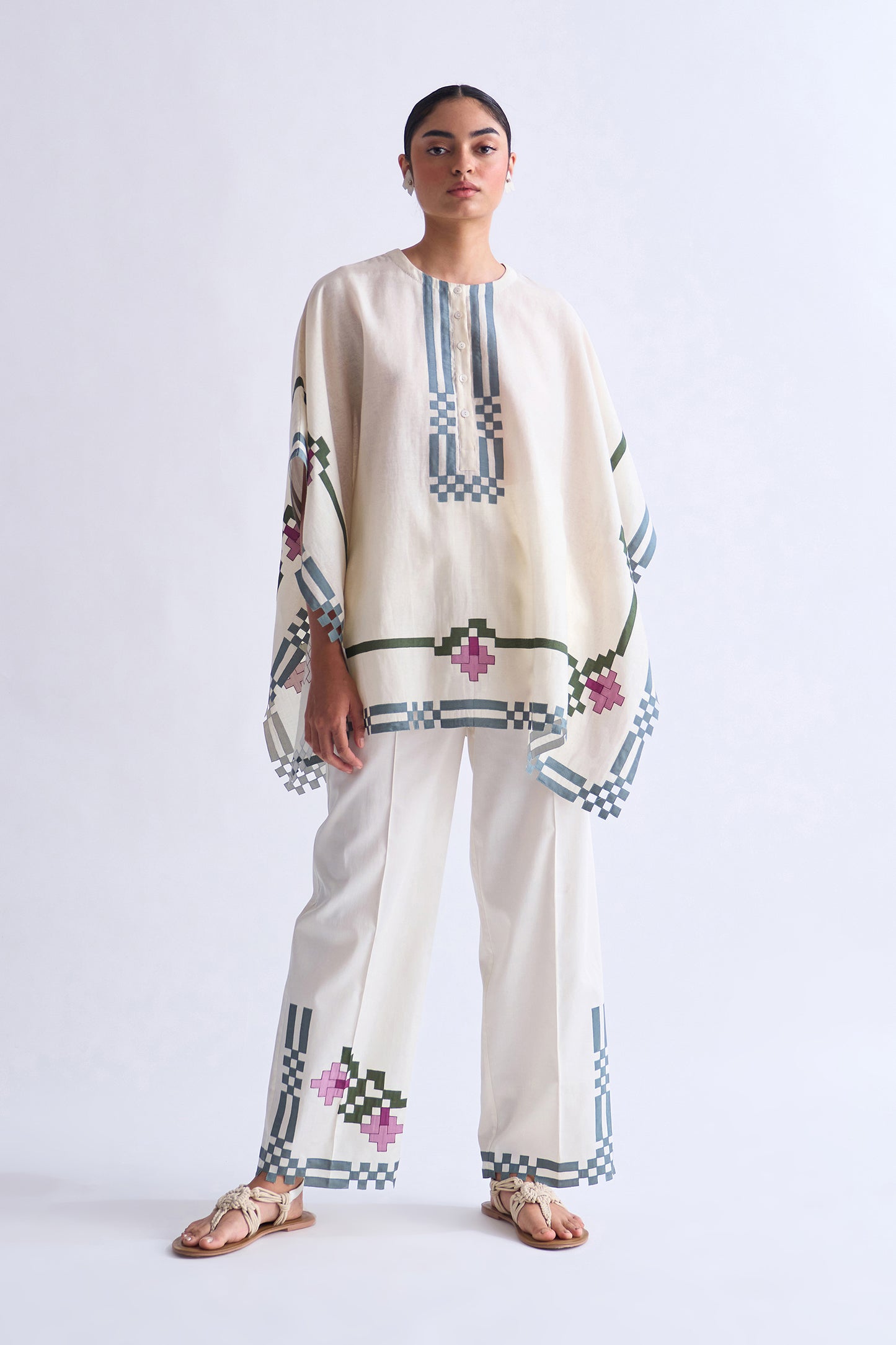 Woman wearing a traditional outfit with embroidered patterns on a white background