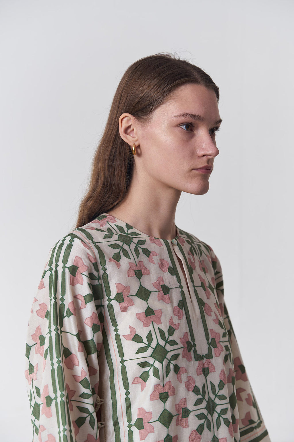 Woman wearing a floral patterned shirt against a white background