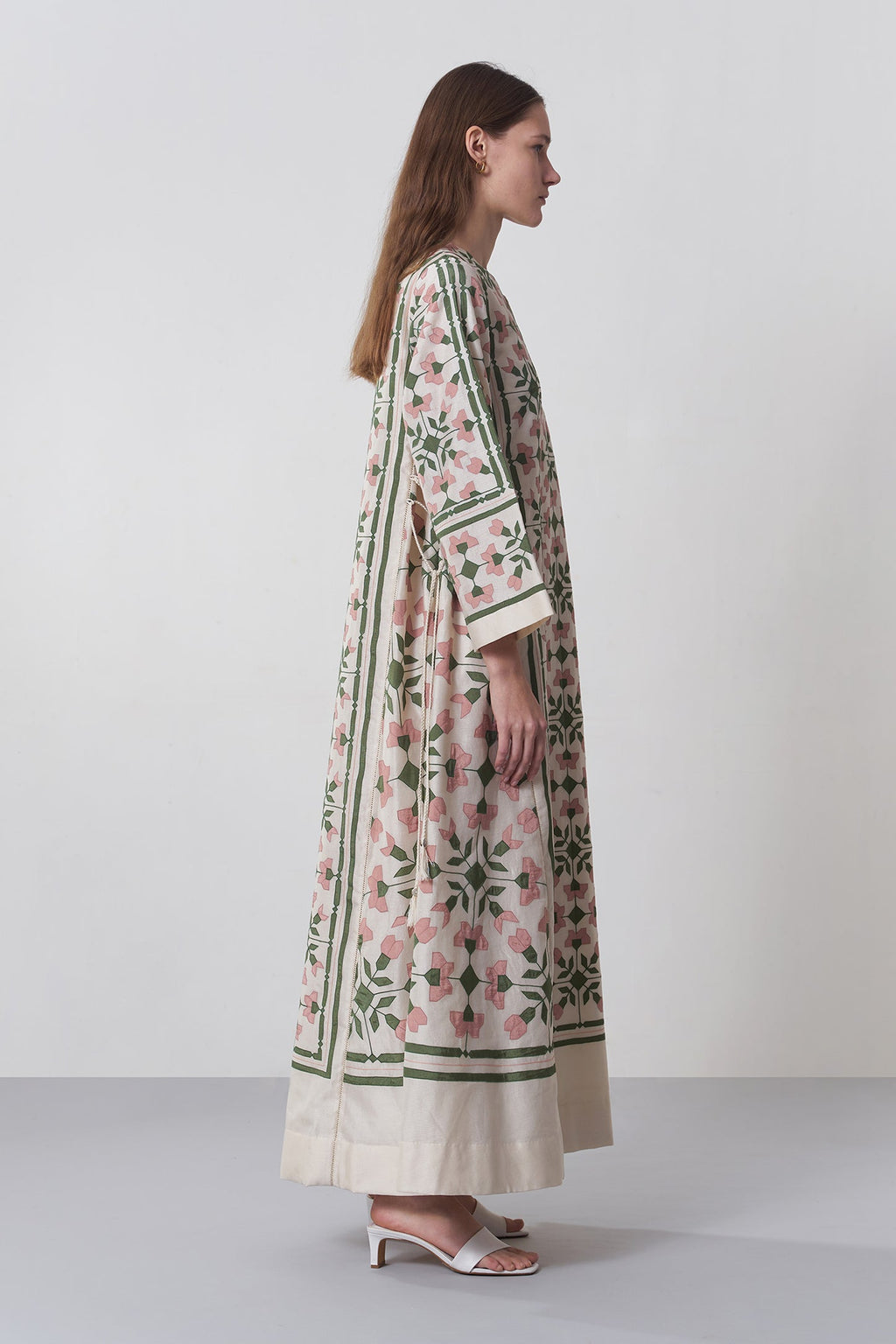 Woman wearing a floral kimono-style garment on a white background