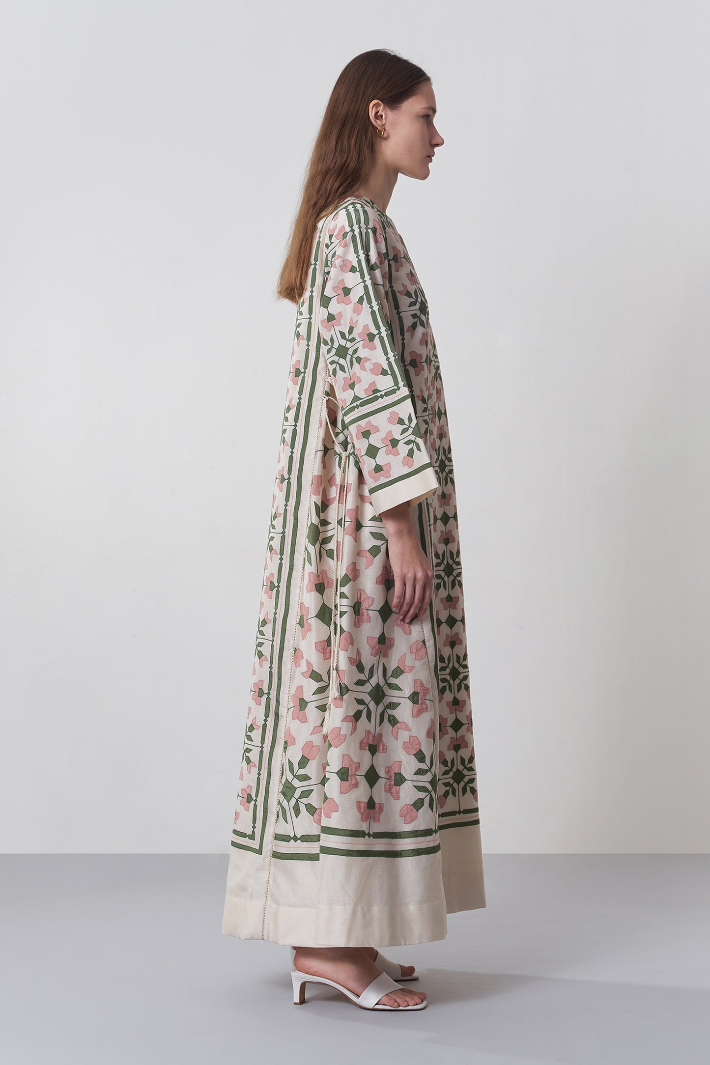 Woman wearing a floral kimono-style garment on a white background