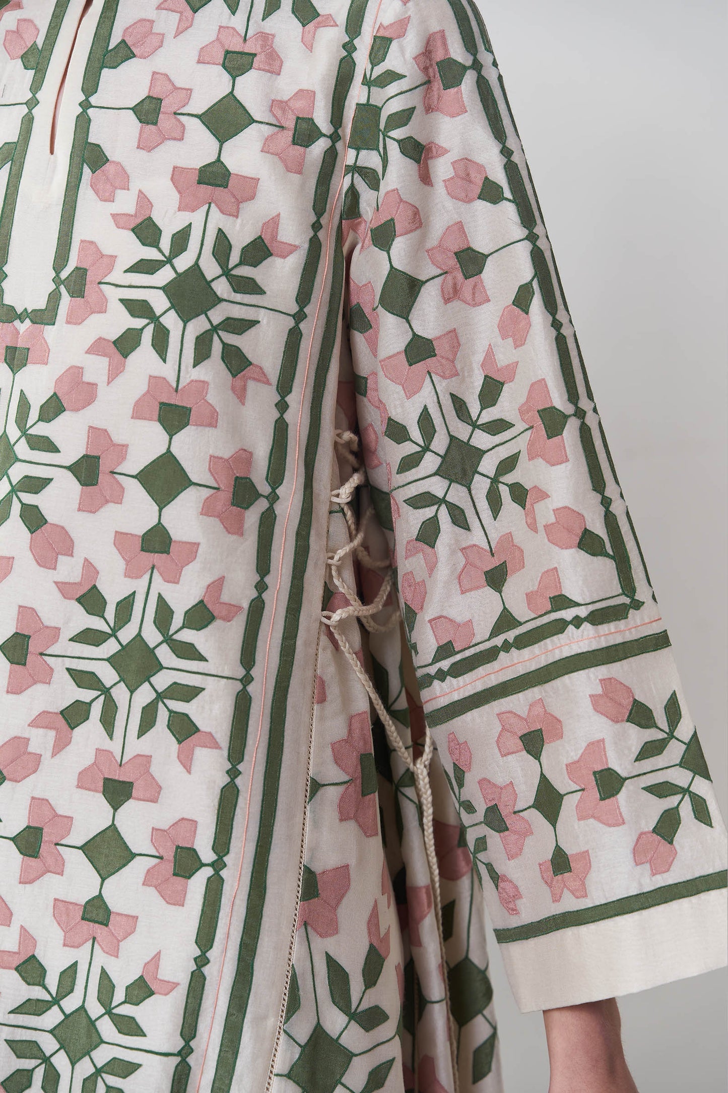 Patterned garment with pink and green design on a plain background