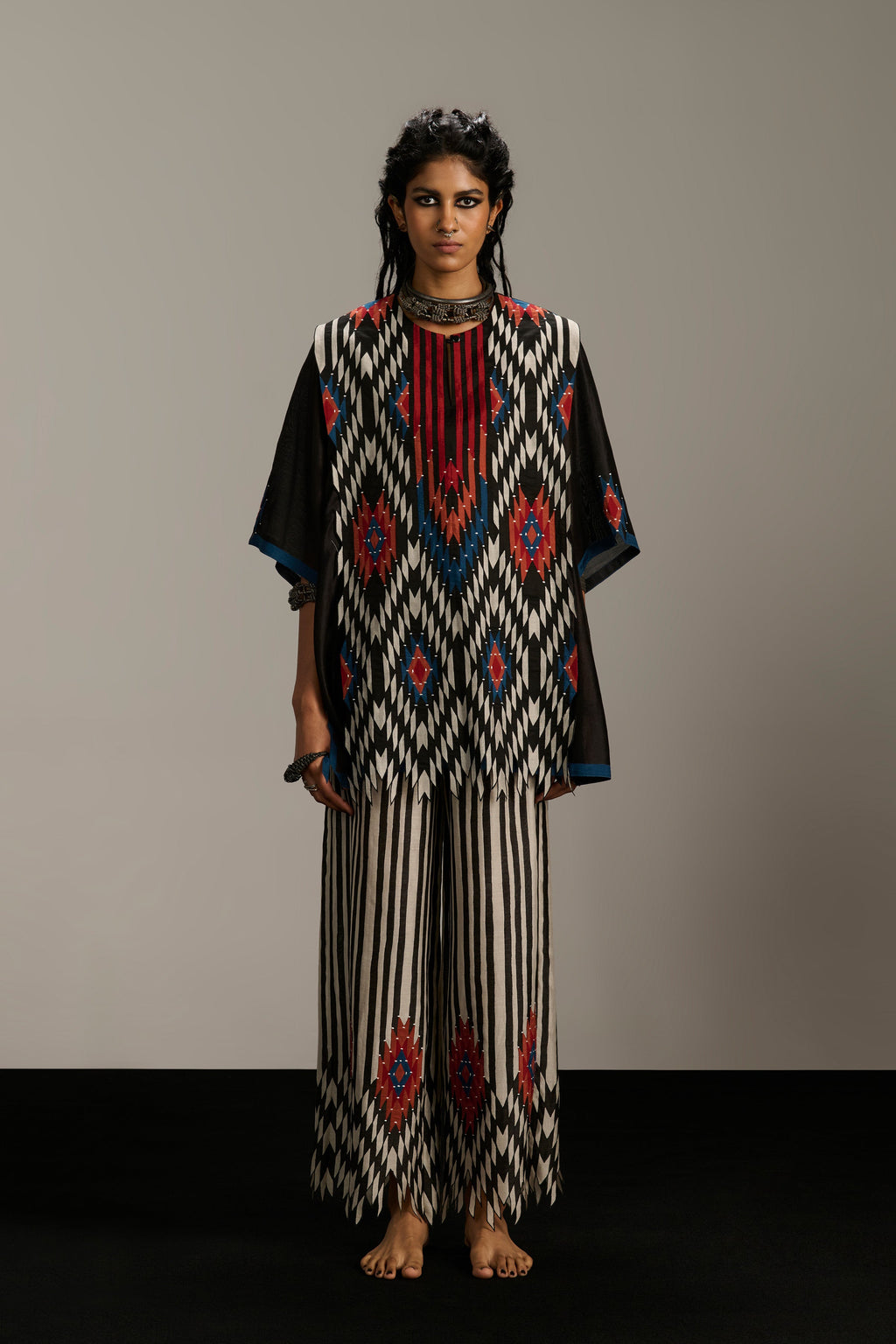 Woman wearing a patterned outfit against a plain background