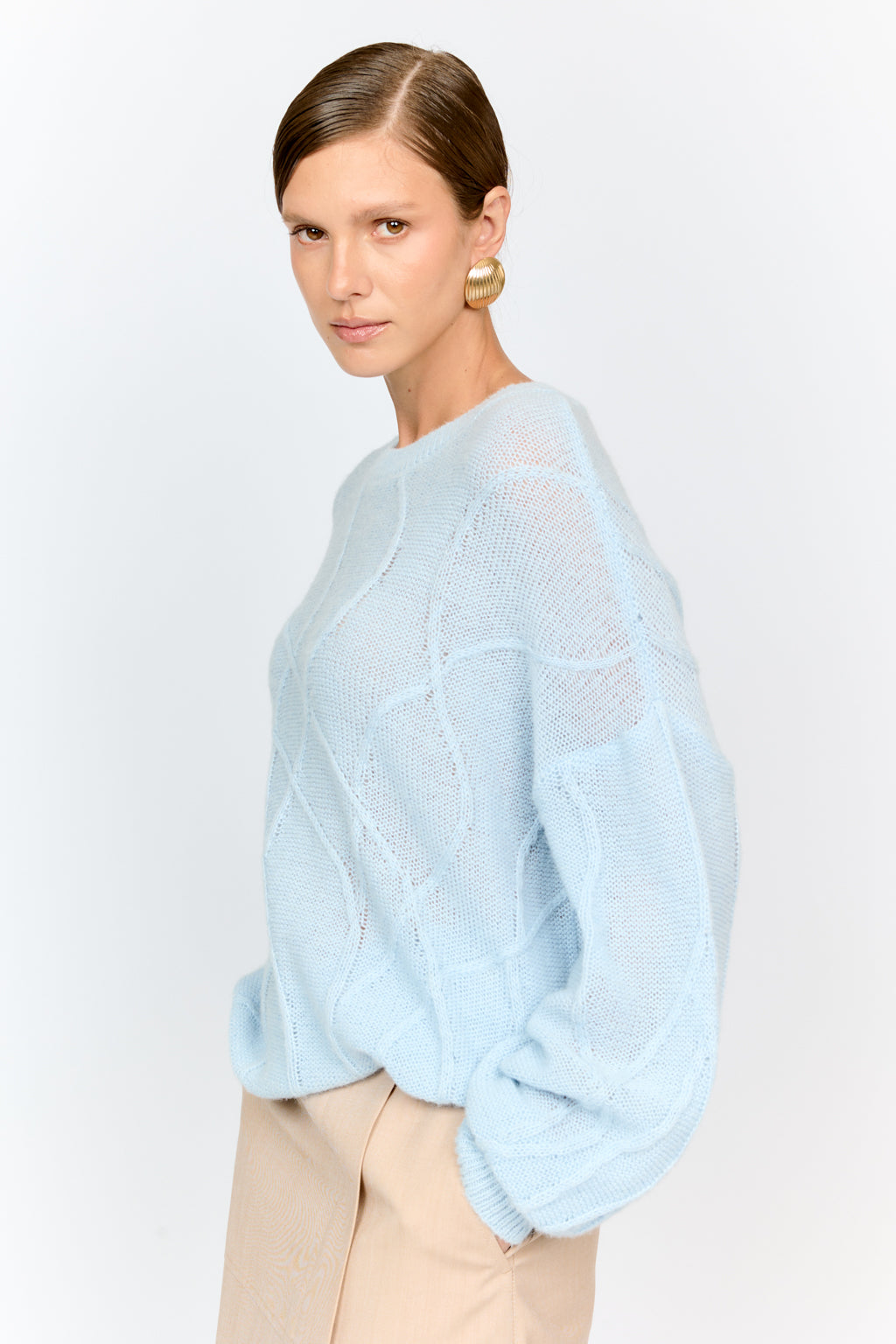 Woman wearing a light blue sweater on a white background