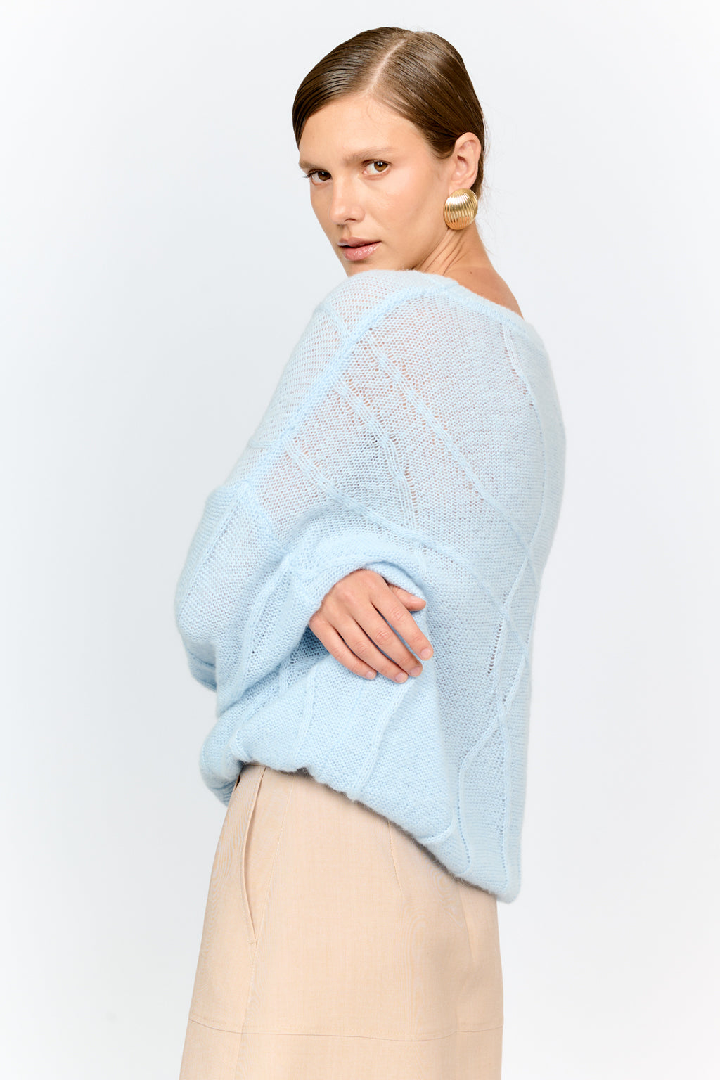 Woman wearing a light blue sweater against a plain background