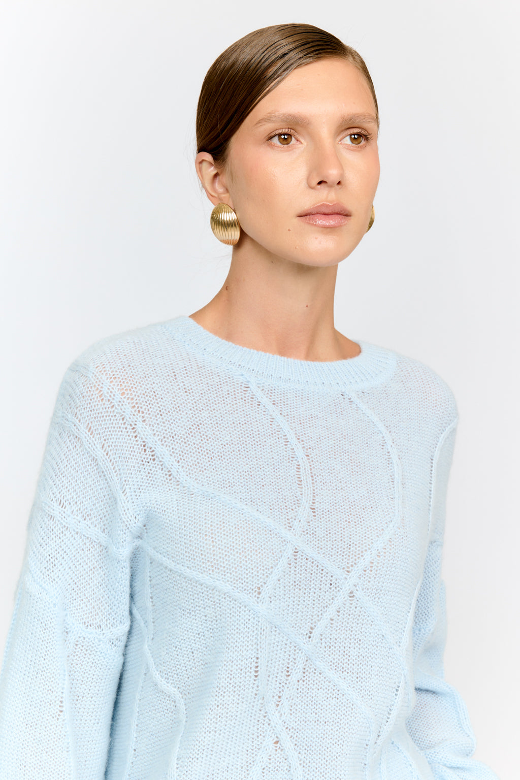 Woman wearing a light blue sweater against a plain background