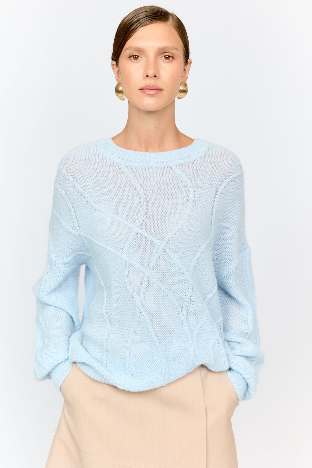 Light blue sweater worn by a model on a plain background
