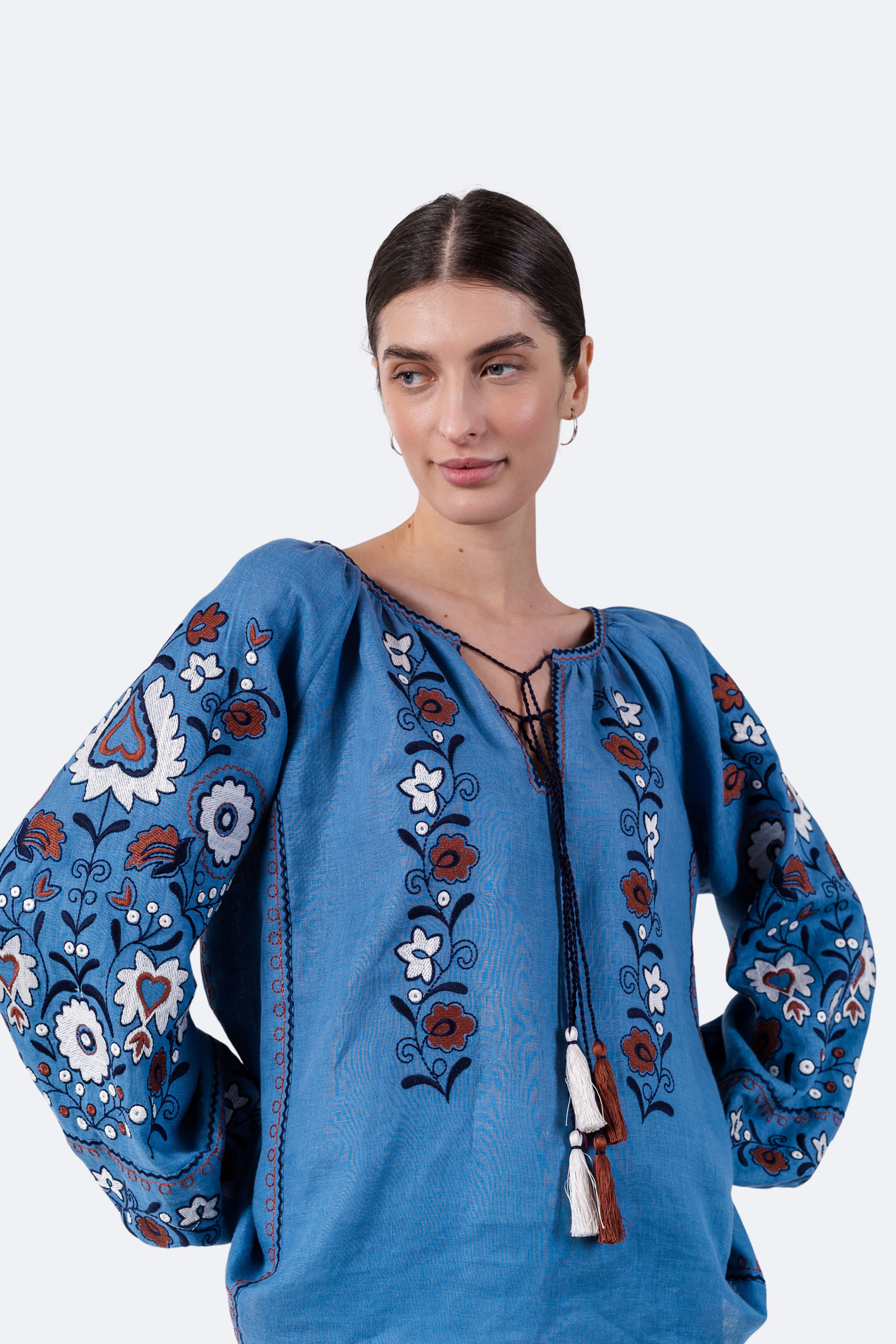 Woman wearing a blue embroidered blouse on a white background