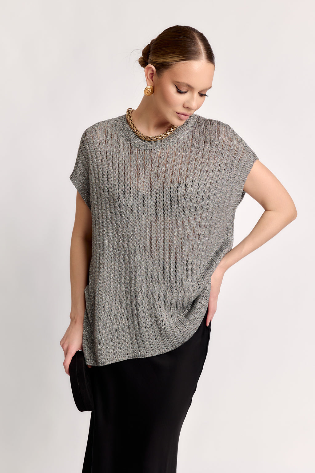 Woman wearing a gray knit top against a white background