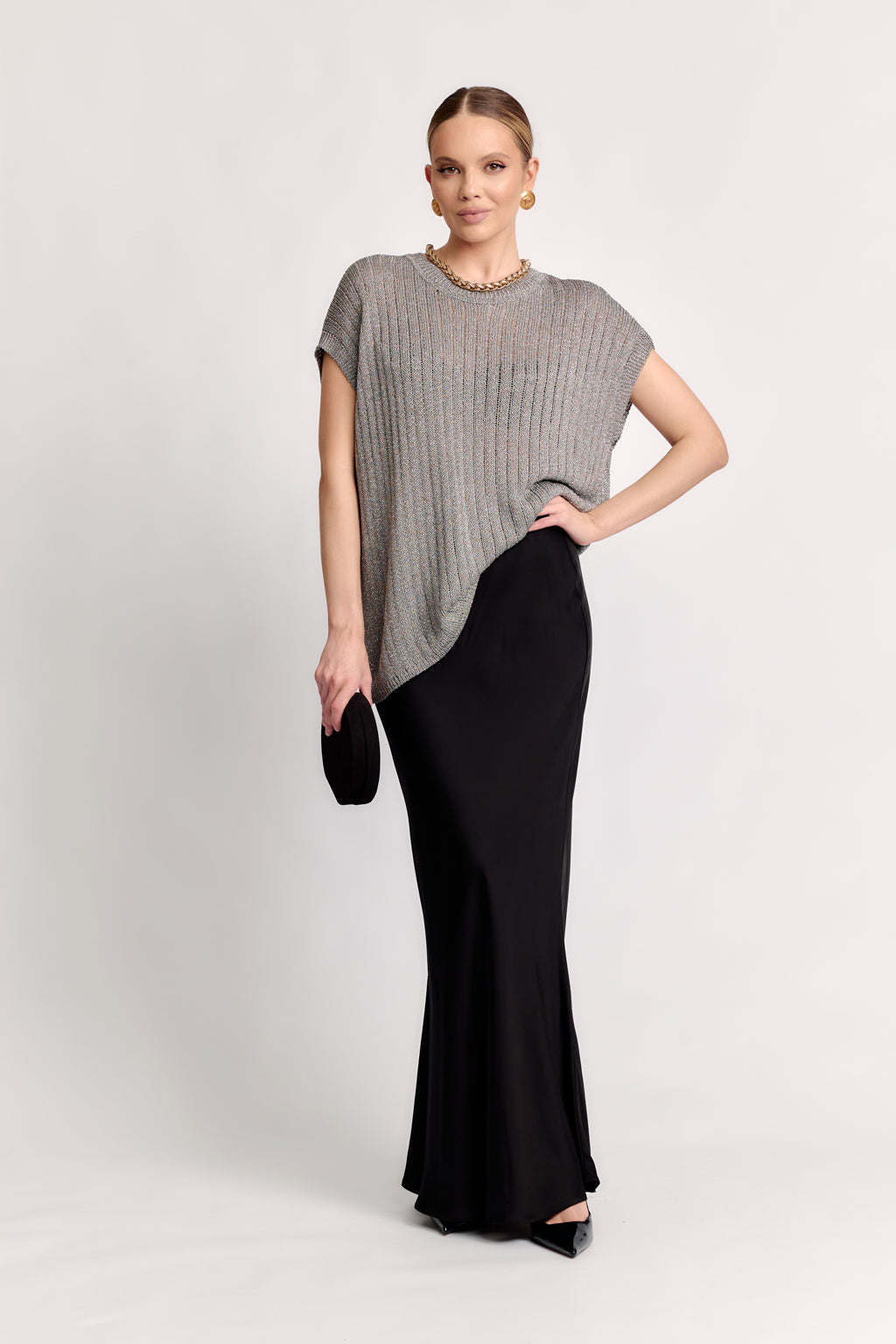 Woman wearing a gray top and black skirt on a white background