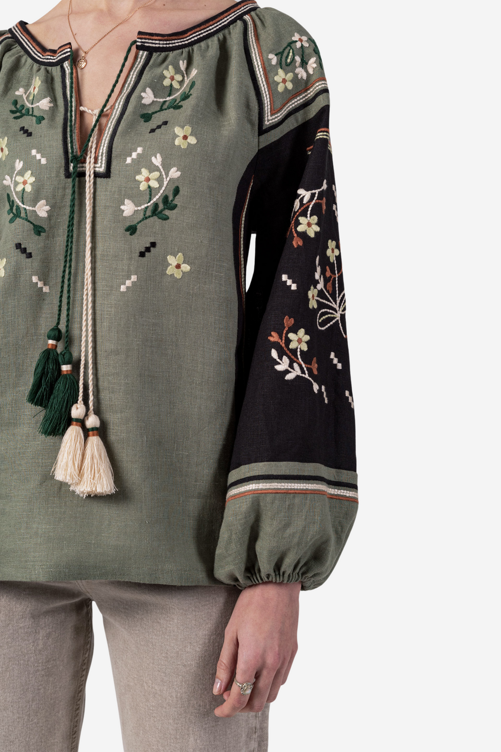 Green embroidered blouse with tassels on a white background