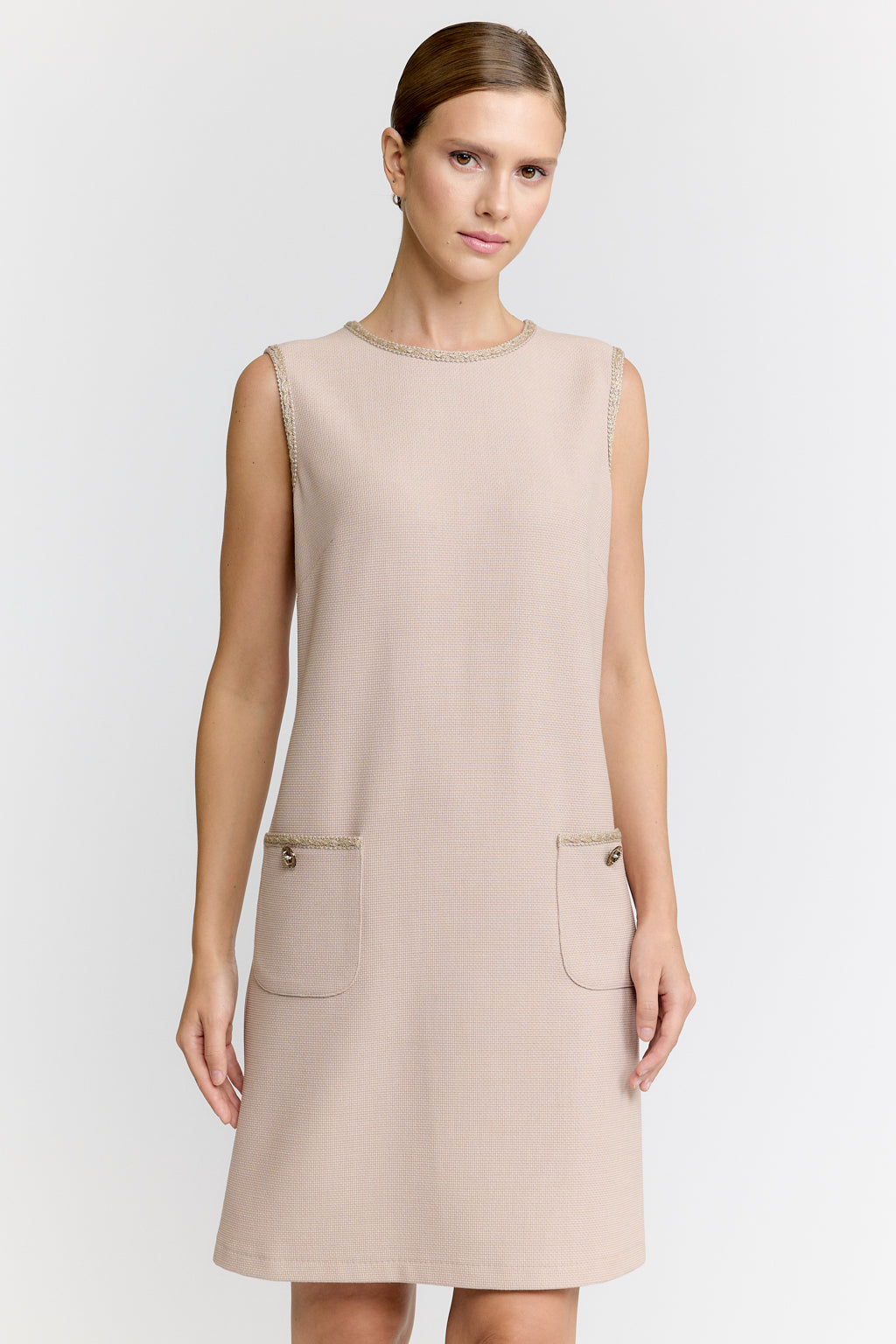 Beige sleeveless dress worn by a model on a white background