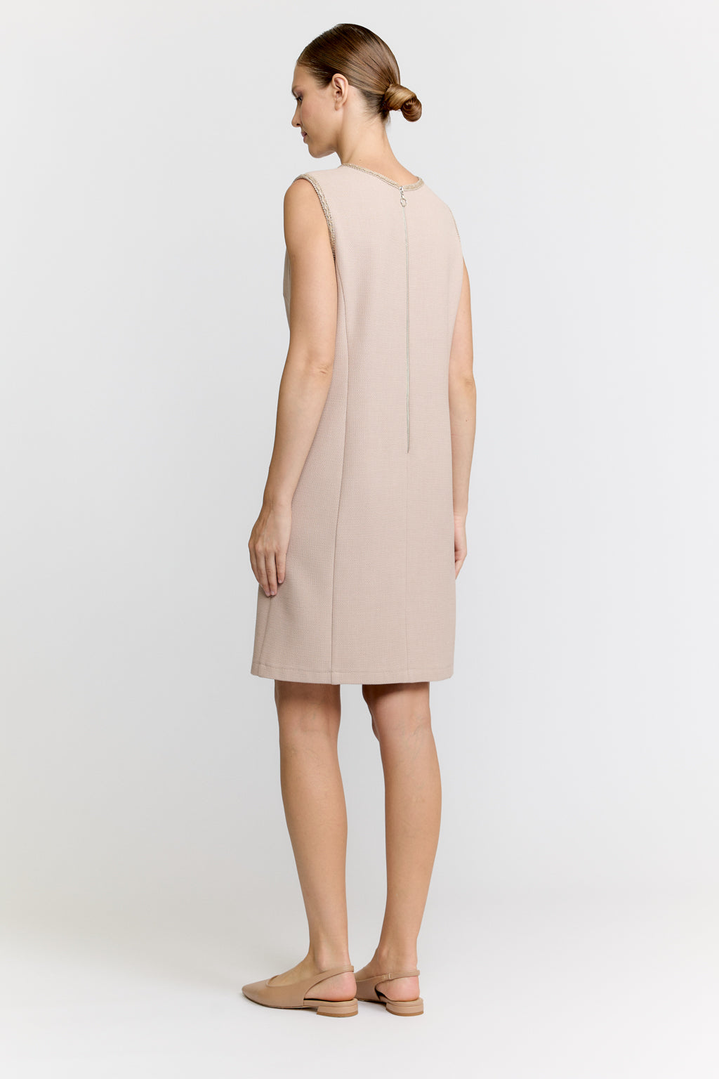 Woman wearing a beige dress on a white background