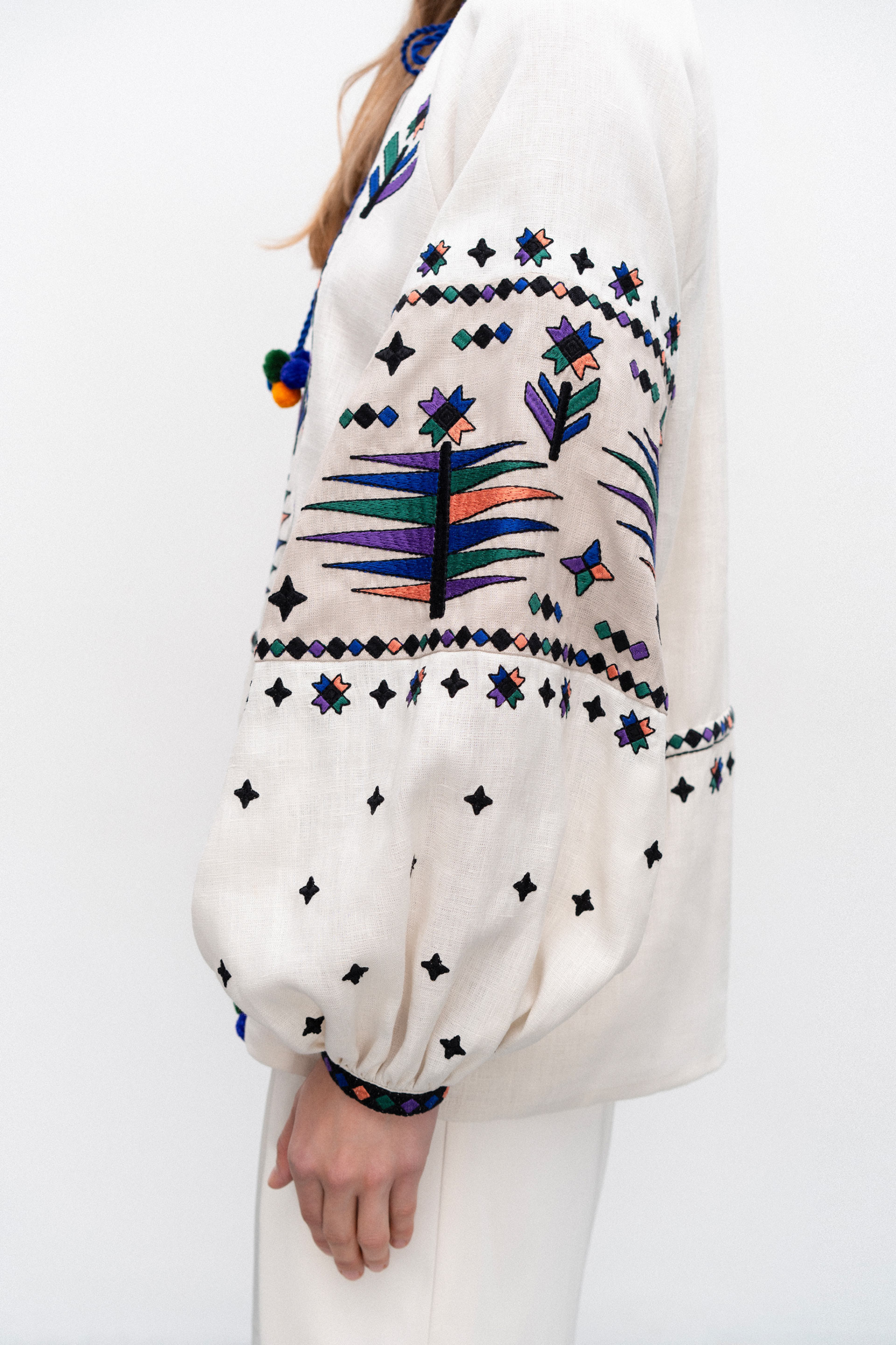 White blouse with colorful embroidery on a white background