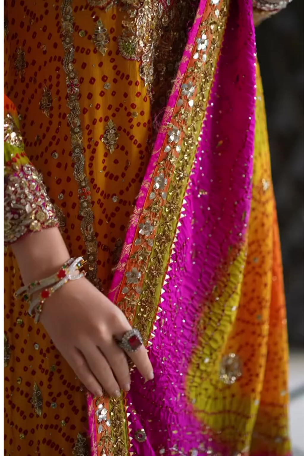 Close-up of a colorful traditional outfit with intricate patterns and jewelry.