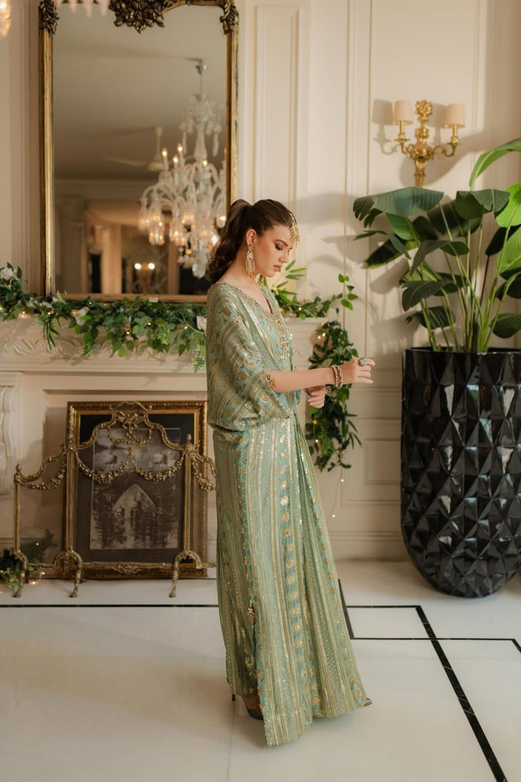 Woman in a green dress standing in an elegant room with decorative elements.