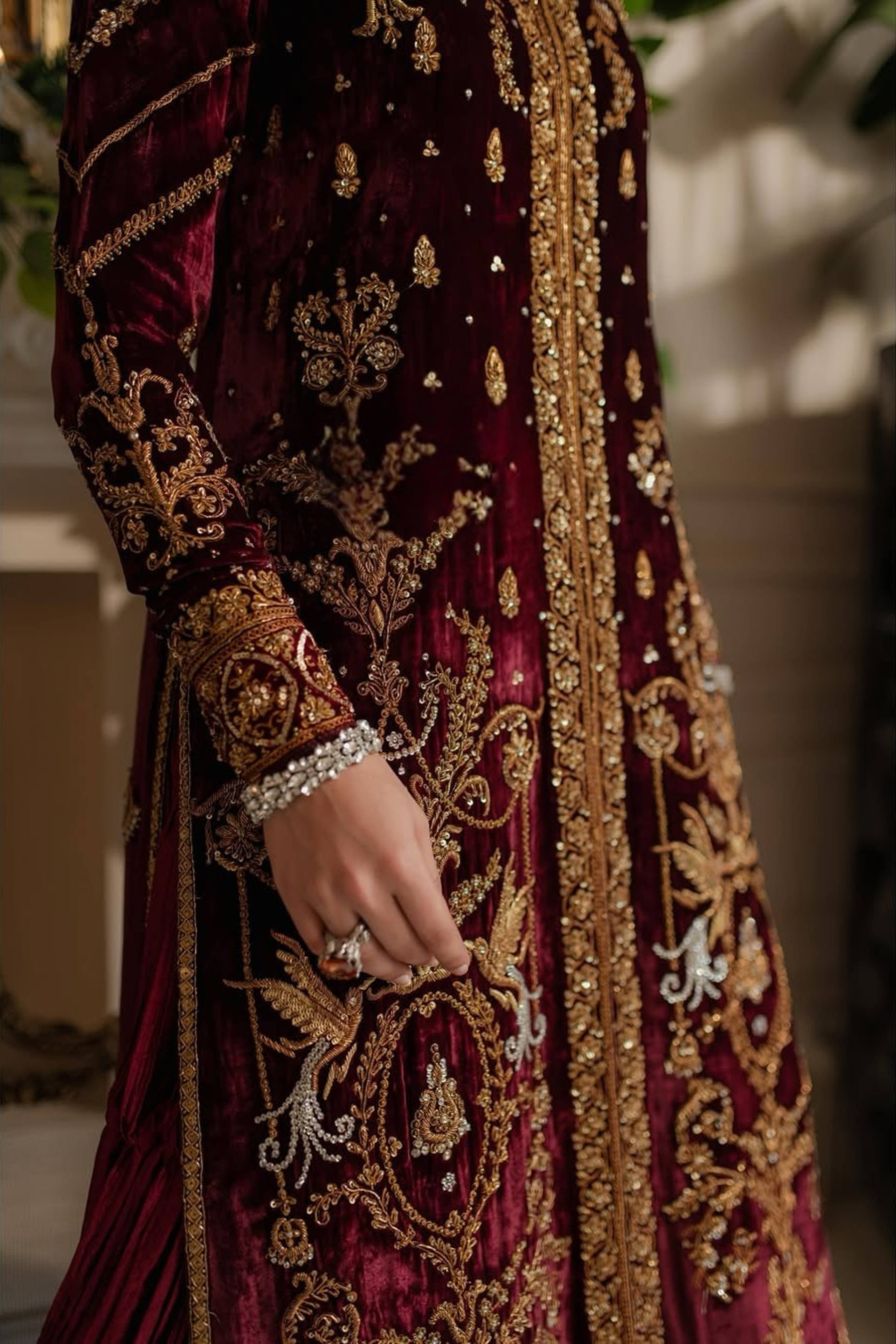 Close-up of a maroon embroidered garment with gold details.