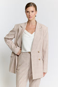 Woman wearing a beige suit on a white background Luxury Women's Wear | Custom-Made, Eco-Friendly Fashion