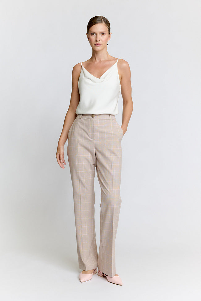 Woman wearing a beige suit on a white background Luxury Women's Wear | Custom-Made, Eco-Friendly Fashion