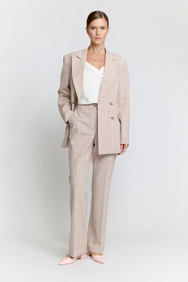 Woman wearing a beige suit on a white background