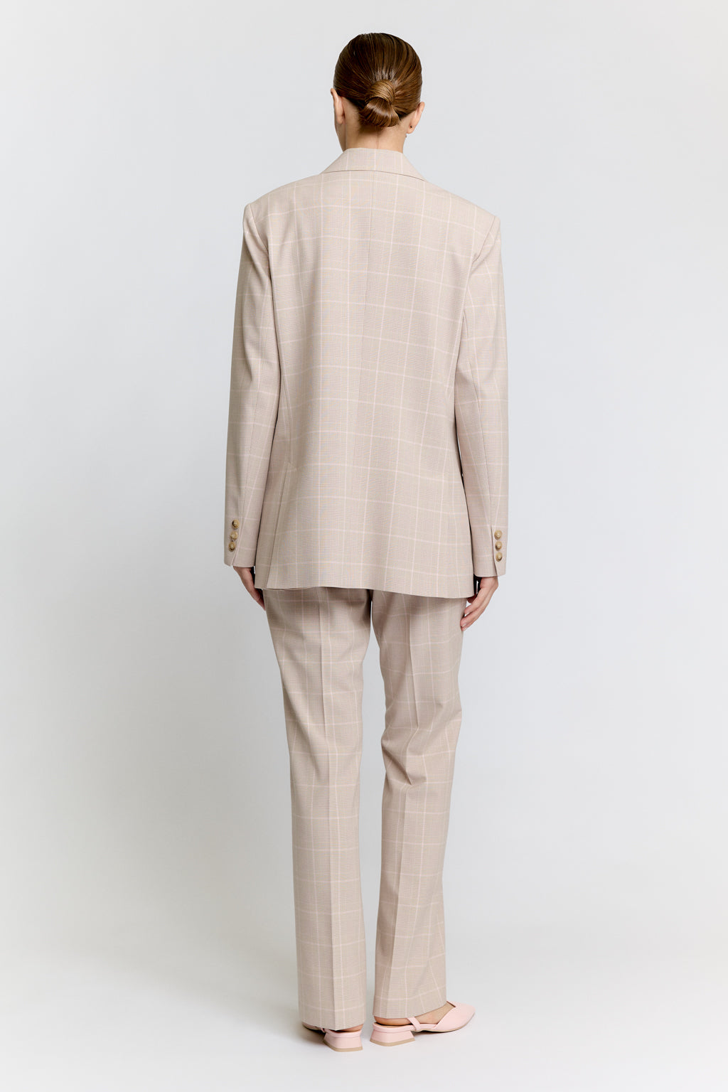 Woman wearing a beige suit on a white background Luxury Women's Wear | Custom-Made, Eco-Friendly Fashion