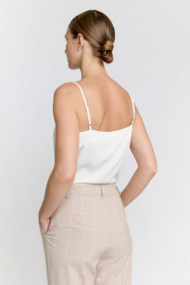 Woman wearing a beige suit on a white background Luxury Women's Wear | Custom-Made, Eco-Friendly Fashion