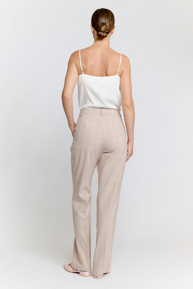 Woman wearing a beige suit on a white background Luxury Women's Wear | Custom-Made, Eco-Friendly Fashion