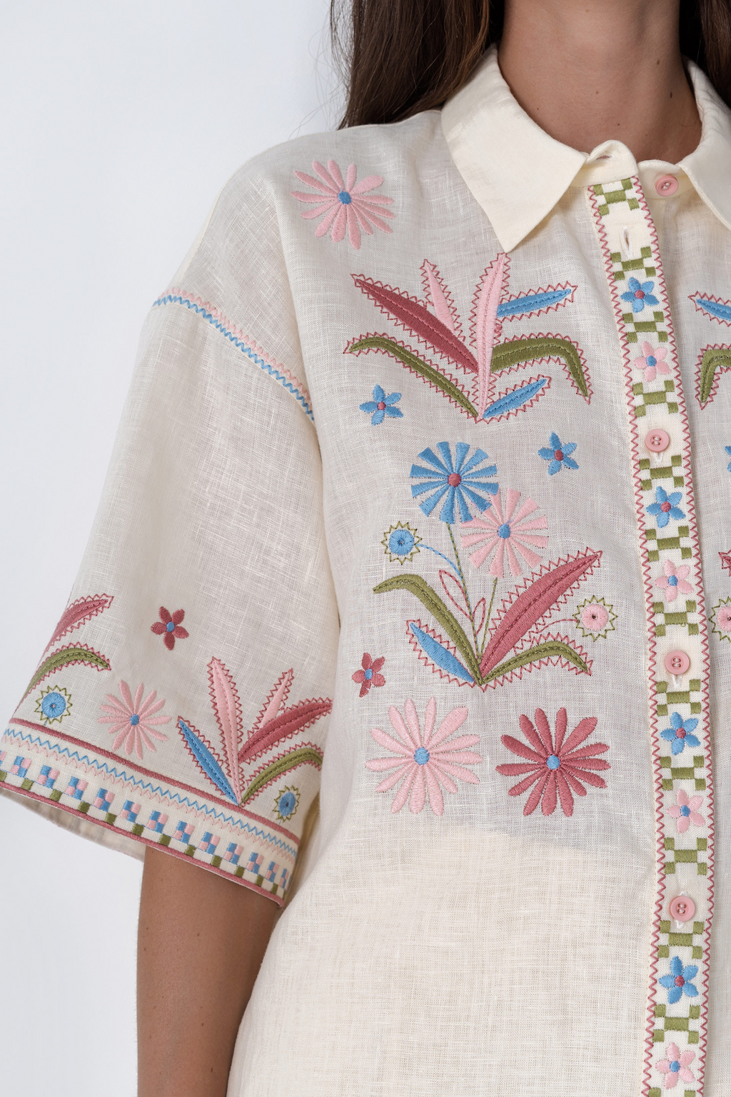 Beige embroidered blouse with floral patterns on a white background