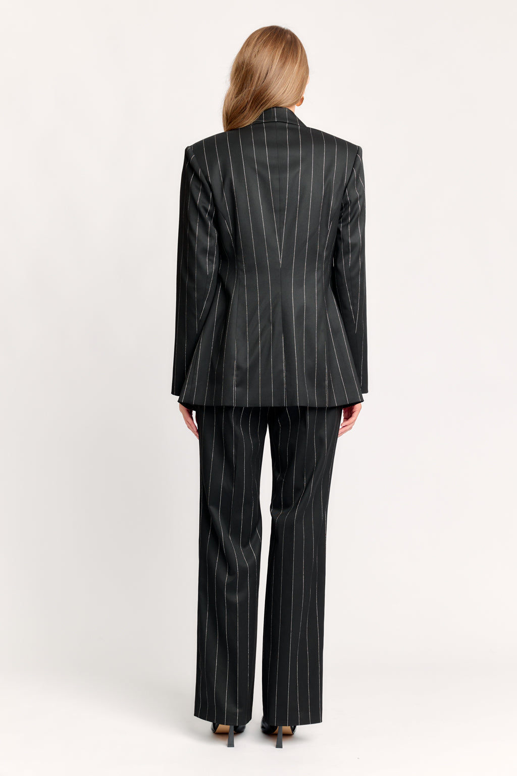 Woman wearing a black pinstripe suit on a white background