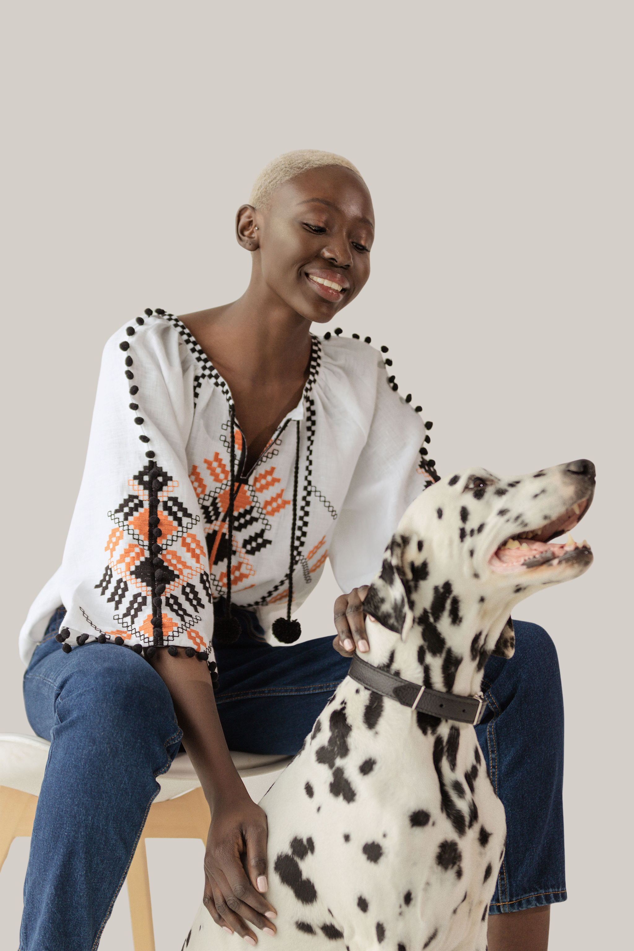 Woman sitting with a Dalmatian dog on a white background