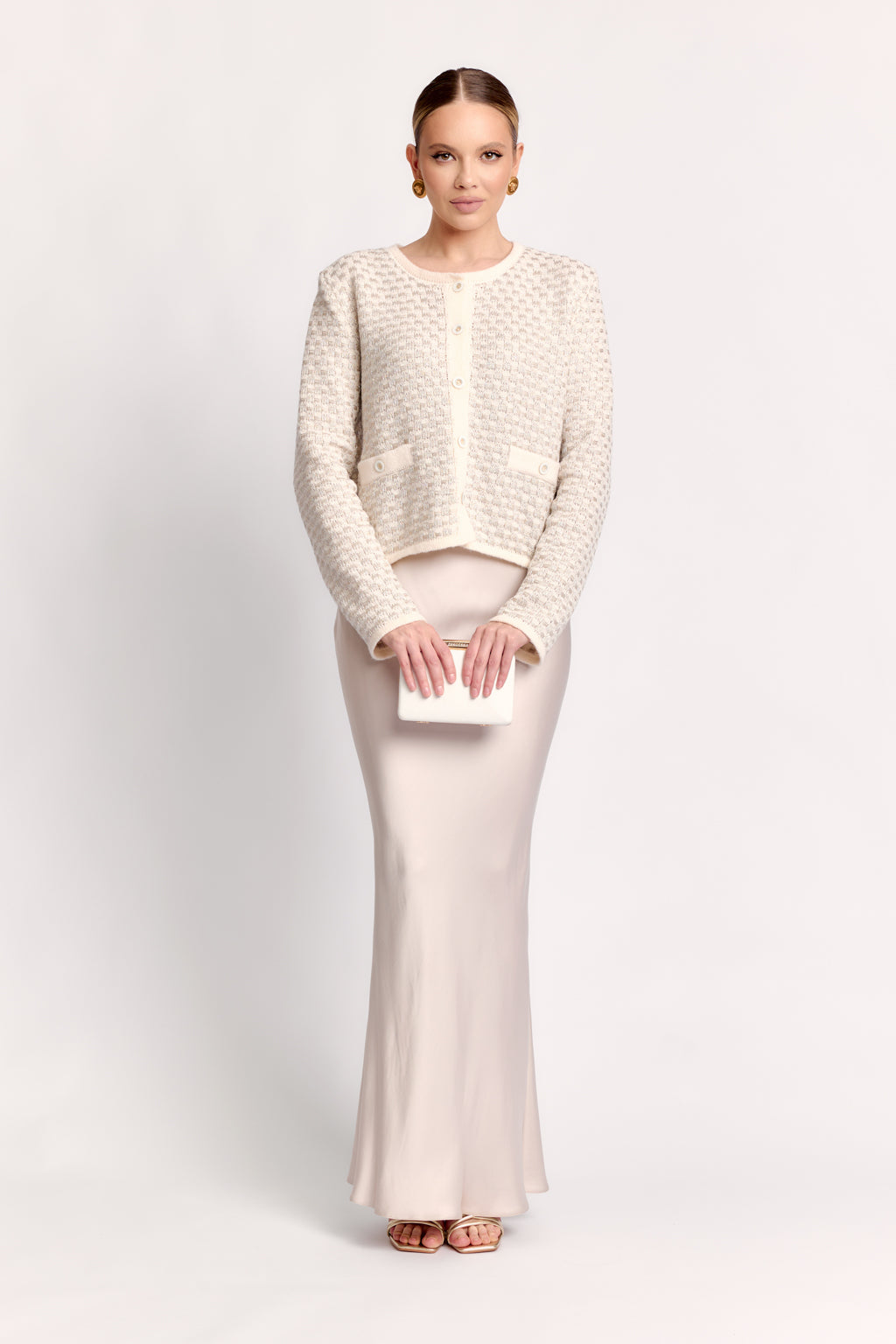 Woman wearing a cream-colored outfit on a white background