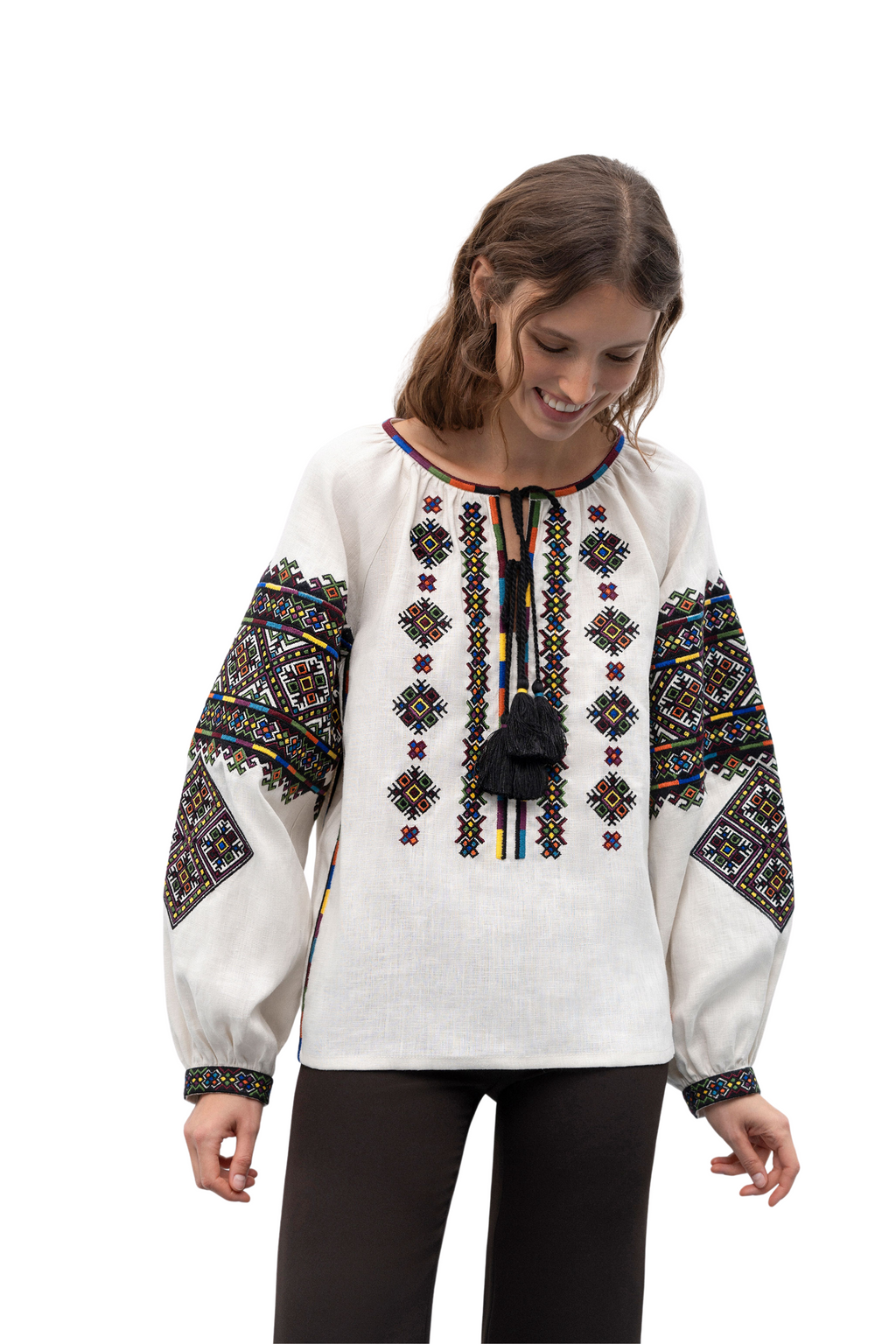 Woman wearing a white blouse with colorful embroidery on a white background